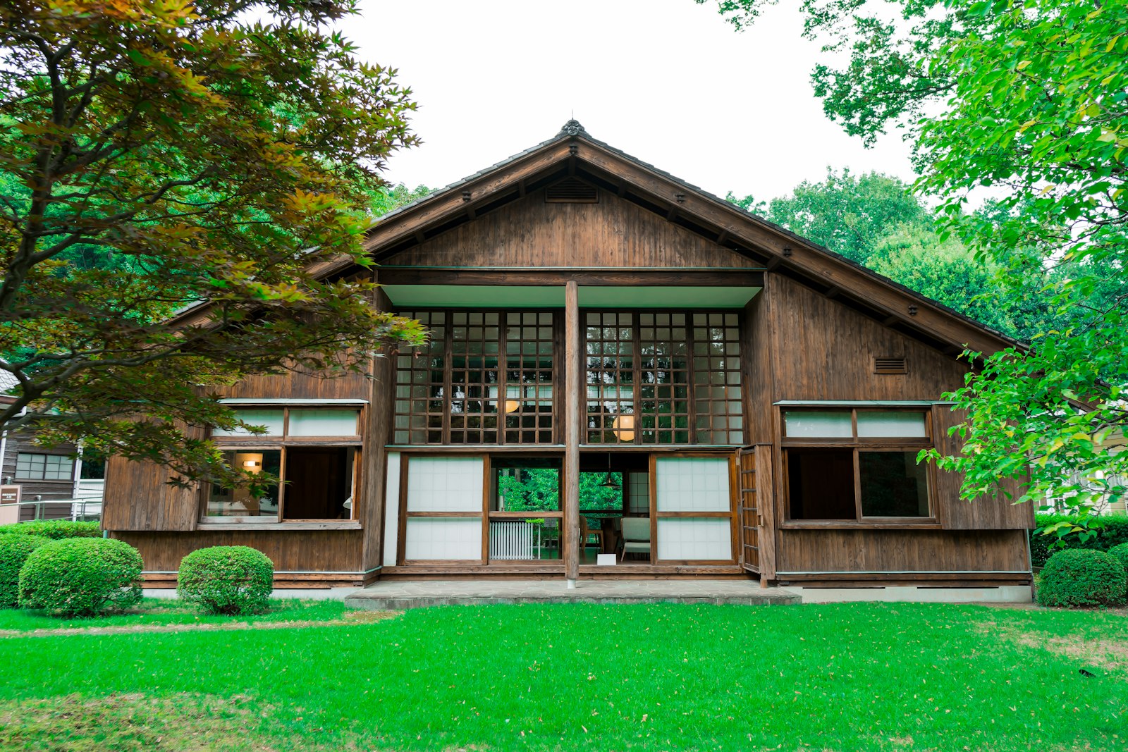 木の外壁の平屋と、手入れされた庭